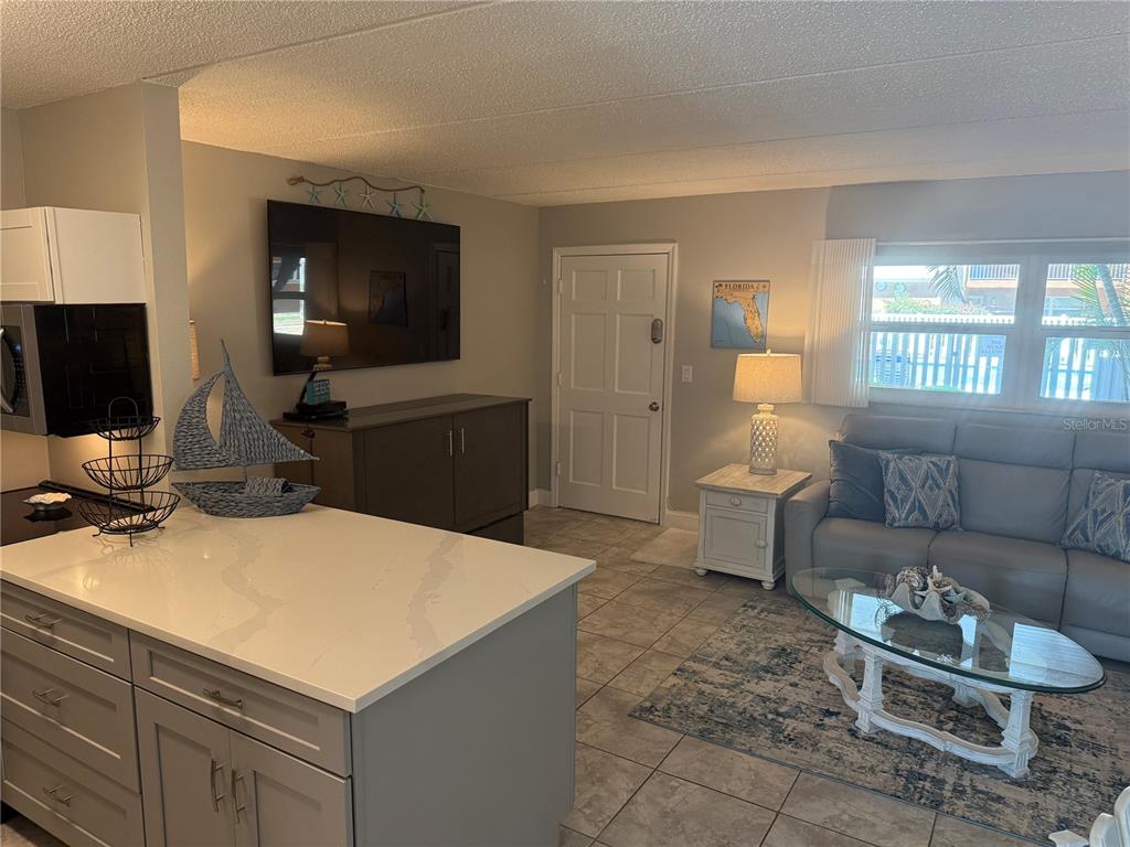 12760 Indian Rocks Road, Unit 1024 Largo, FL 33774 - Photo 13 of 35 a living room with furniture a window and a flat screen tv