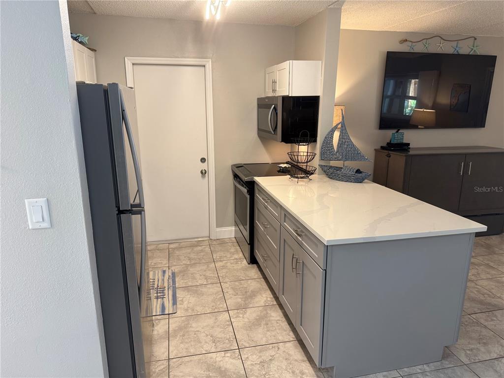 12760 Indian Rocks Road, Unit 1024 Largo, FL 33774 - Photo 18 of 35 a kitchen with stainless steel appliances a refrigerator oven a sink a stove and a refrigerator