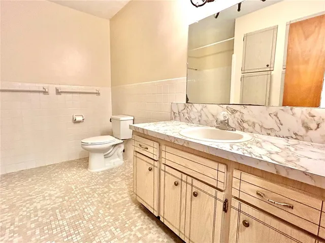 a bathroom with a sink a toilet and a mirror