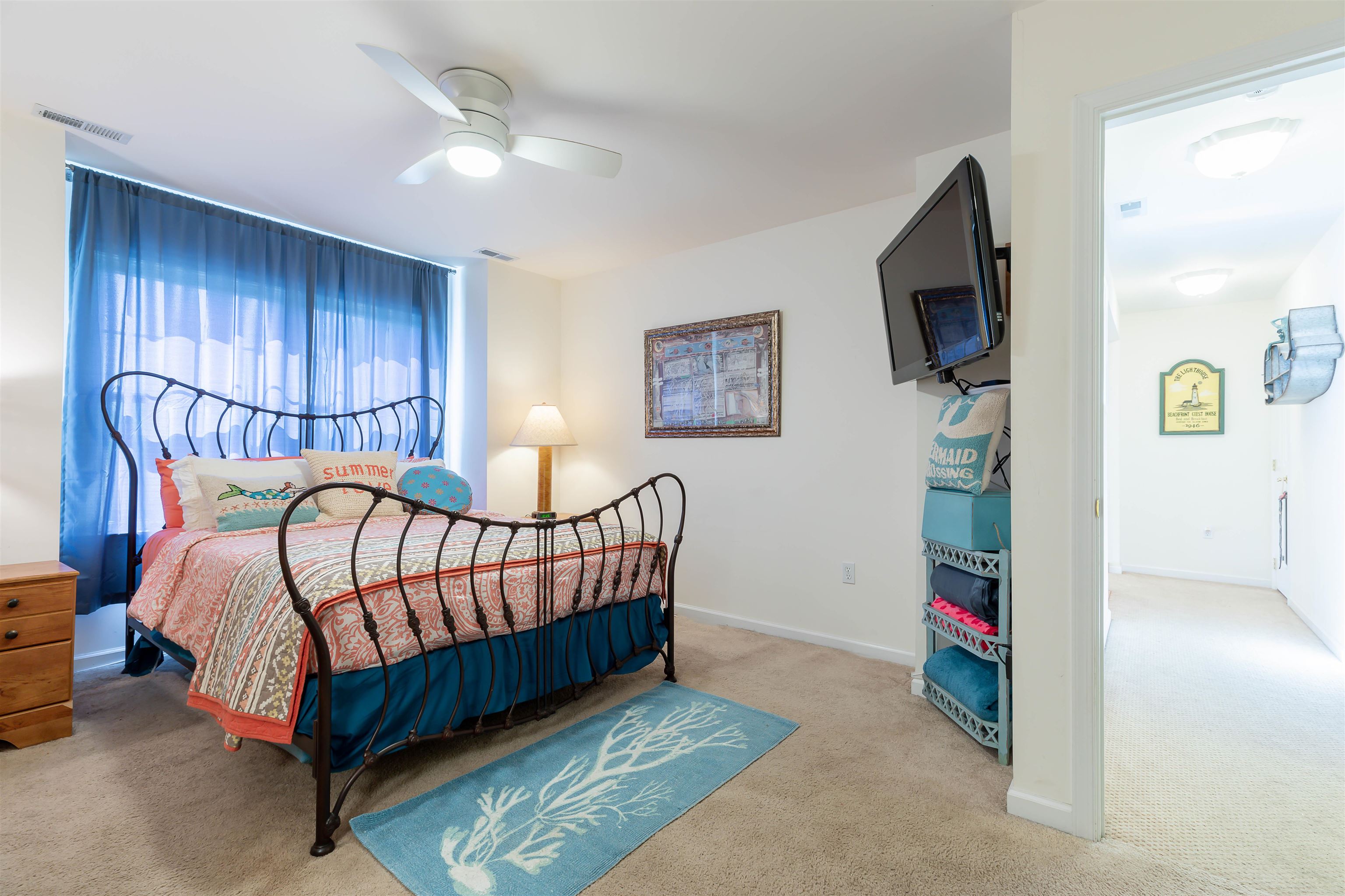 3125 Shunpike Road, Unit A Rio Grande, NJ 08242 - Photo 24 of 41 a bedroom with a bed a flat screen tv and chandelier