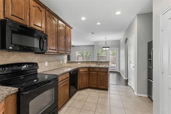 a kitchen with stainless steel appliances granite countertop a sink refrigerator and cabinets