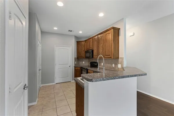 a kitchen with stainless steel appliances granite countertop a sink and a refrigerator