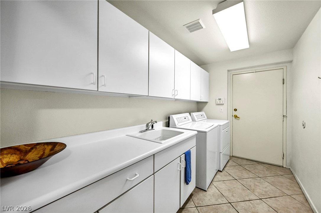 10730 Amber Ridge Drive, Unit 101 Las Vegas, NV 89144 - Photo 28 of 32 Ample storage and a convenient utility sink define this efficient laundry area.