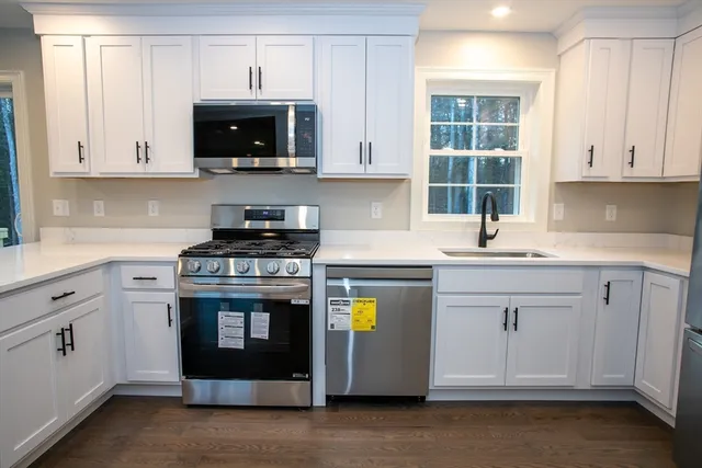 a kitchen with stainless steel appliances granite countertop a stove and a white cabinets