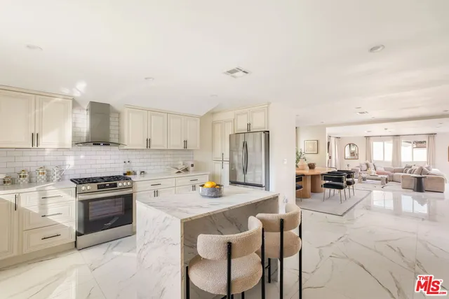 a kitchen with stainless steel appliances kitchen island granite countertop a refrigerator and a stove