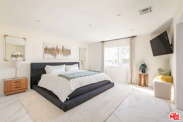 a bedroom with a large bed and a night stand