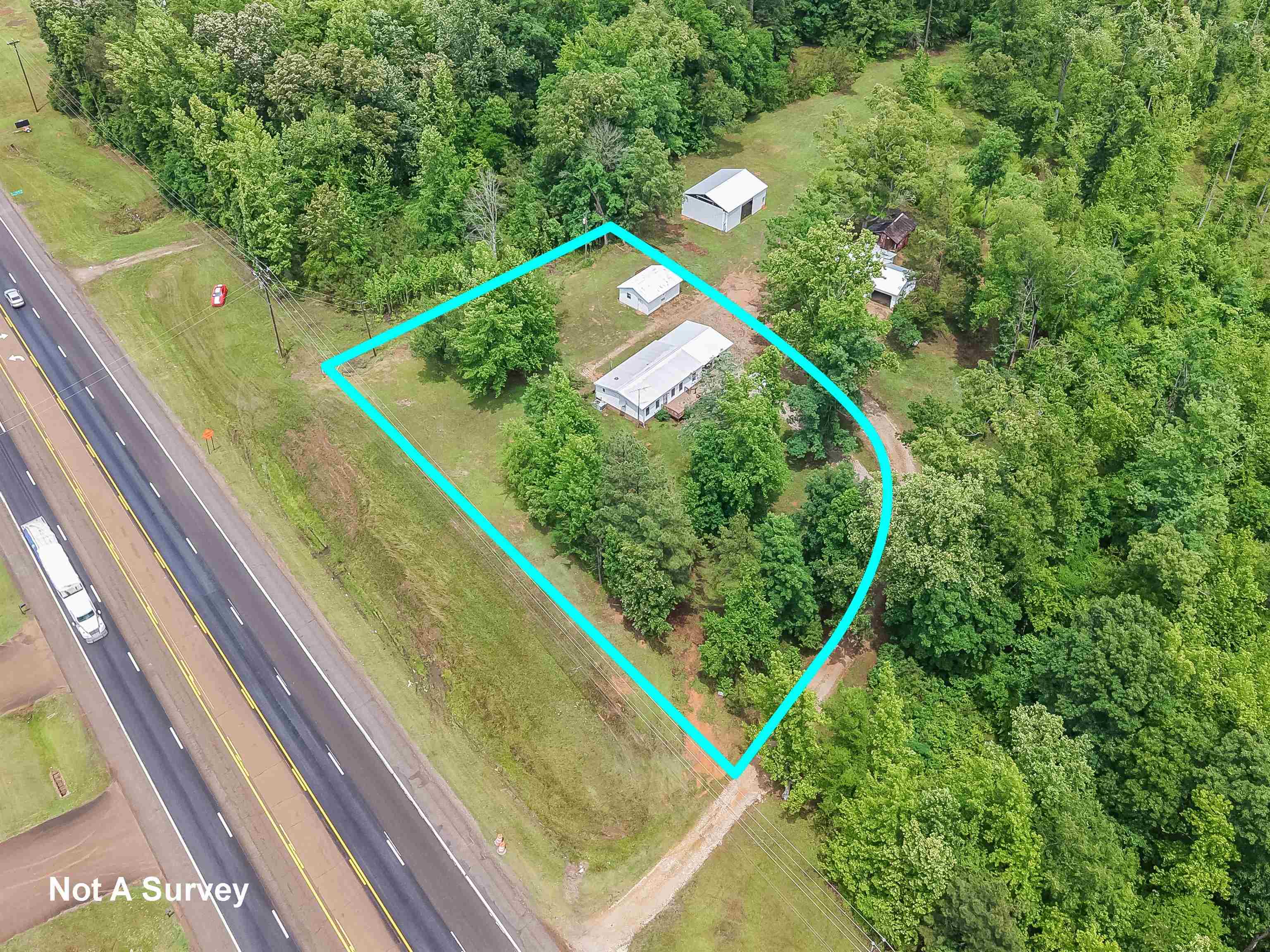 6264 45th Highway South Ramer, TN 38367 - Photo 10 of 24 Property parcel with mature trees, a single-story residence, and two outbuildings