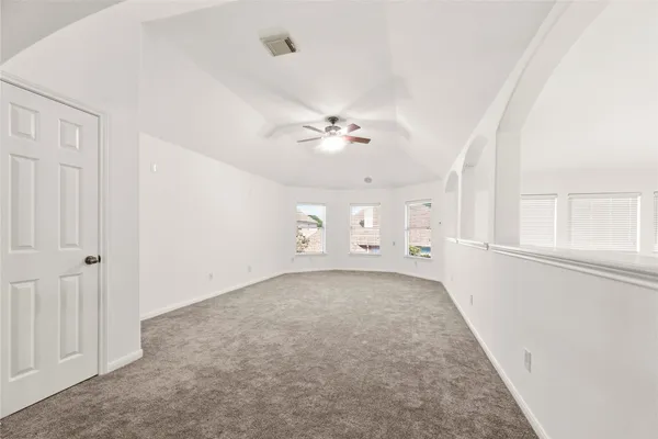 an empty room with a ceiling fan and a window