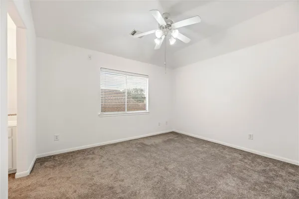 an empty room with a chandelier fan