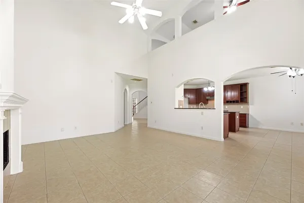 en empty room with a fireplace and chandelier