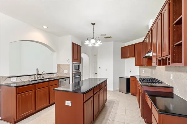 a kitchen with stainless steel appliances granite countertop a stove and a sink