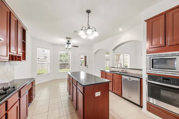 a large kitchen with stainless steel appliances granite countertop a stove oven and a refrigerator