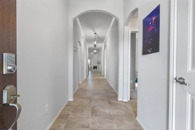a view of a hallway with wooden floor and a bathroom