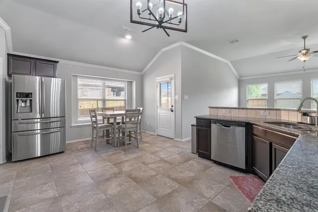a kitchen with stainless steel appliances granite countertop a refrigerator and a stove top oven