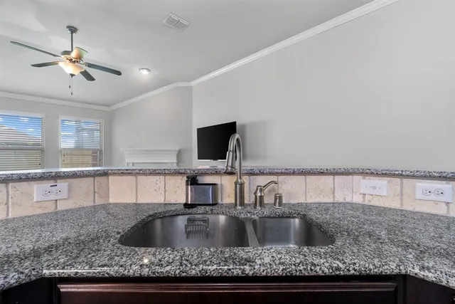 a kitchen with a sink and a wooden floor