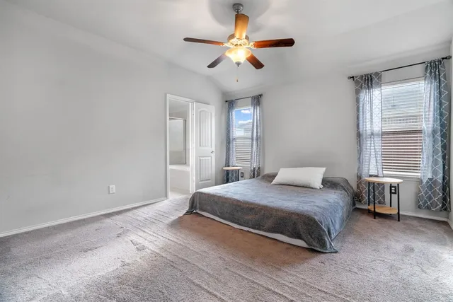 a bedroom with a bed ceiling fan and a window