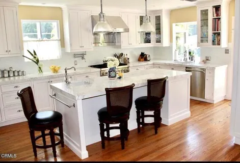a dining room with wooden floor a chandelier a wooden table and chairs