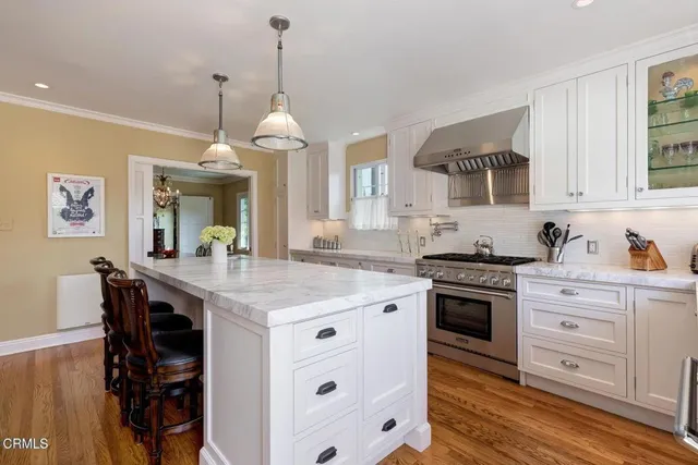 a kitchen with granite countertop a sink a counter space appliances and cabinets