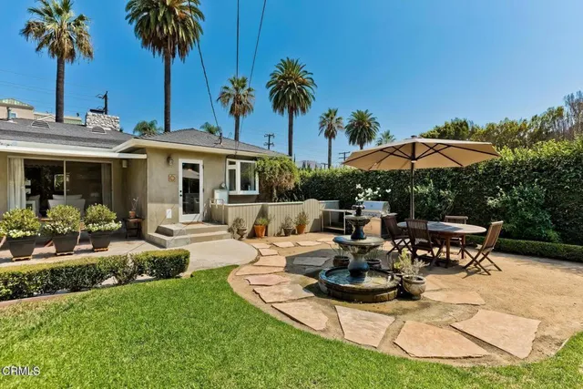 a view of a patio with table and chairs under an umbrella