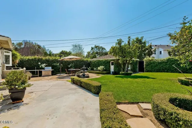 a view of a swimming pool and lounge chairs in back yard of the house