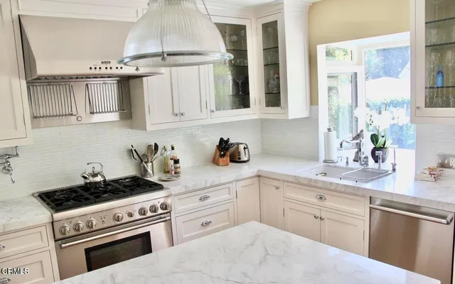 a kitchen with cabinets appliances a sink and a window