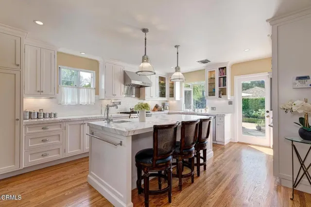 a kitchen with stainless steel appliances granite countertop a kitchen island hardwood floor sink and stove