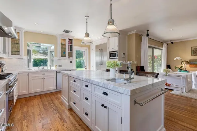 a kitchen with stainless steel appliances granite countertop a sink stove and wooden floor