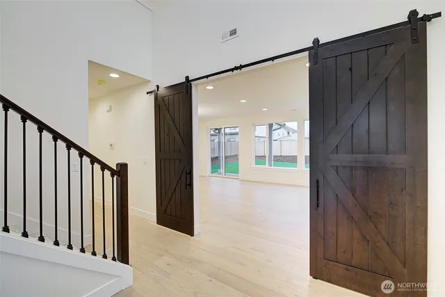 a view of a hallway with wooden floor and staircase
