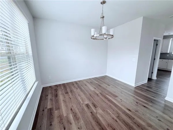 a view of empty room with wooden floor and window