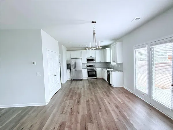 a kitchen with stainless steel appliances a refrigerator and wooden floor