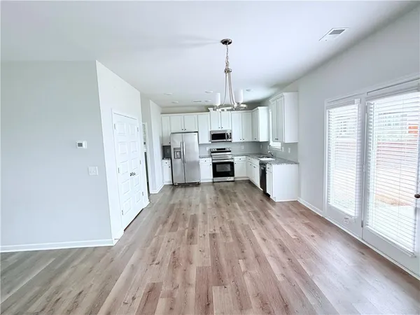 a view of kitchen with granite countertop cabinets and wooden floor