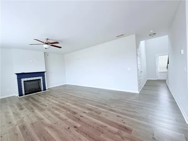 a view of a livingroom with wooden floor and a ceiling fan
