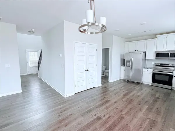 a view of a kitchen with wooden floor and an empty space