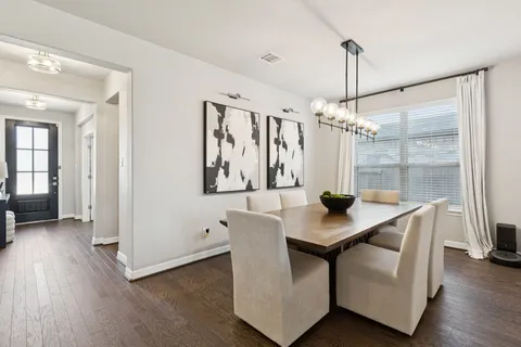 a view of a dining room and livingroom with furniture wooden floor a chandelier