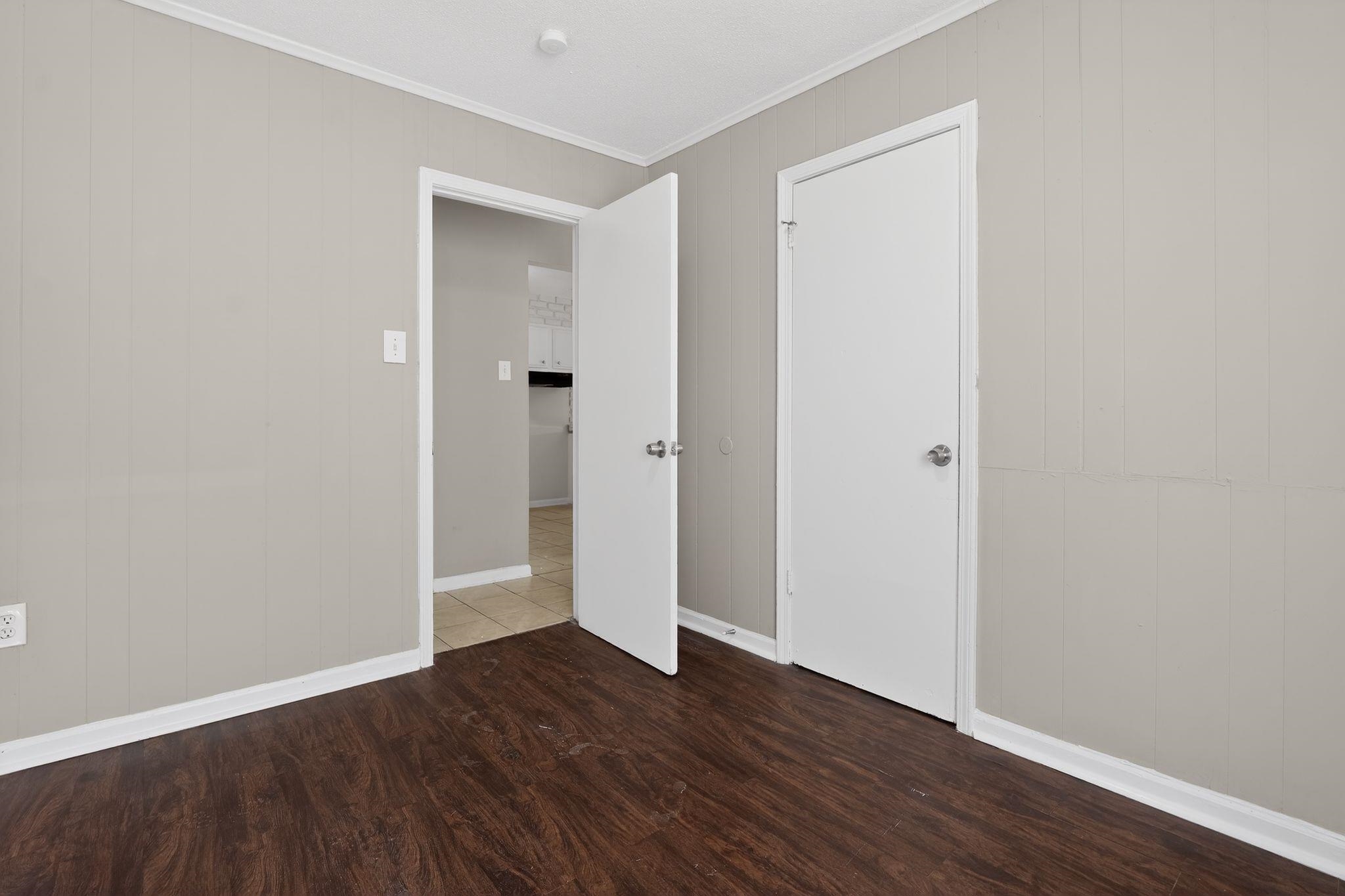 4306 University Street Memphis, TN 38127 - Photo 18 of 26 Unfurnished bedroom with wood finished floors, ornamental molding, and wooden walls