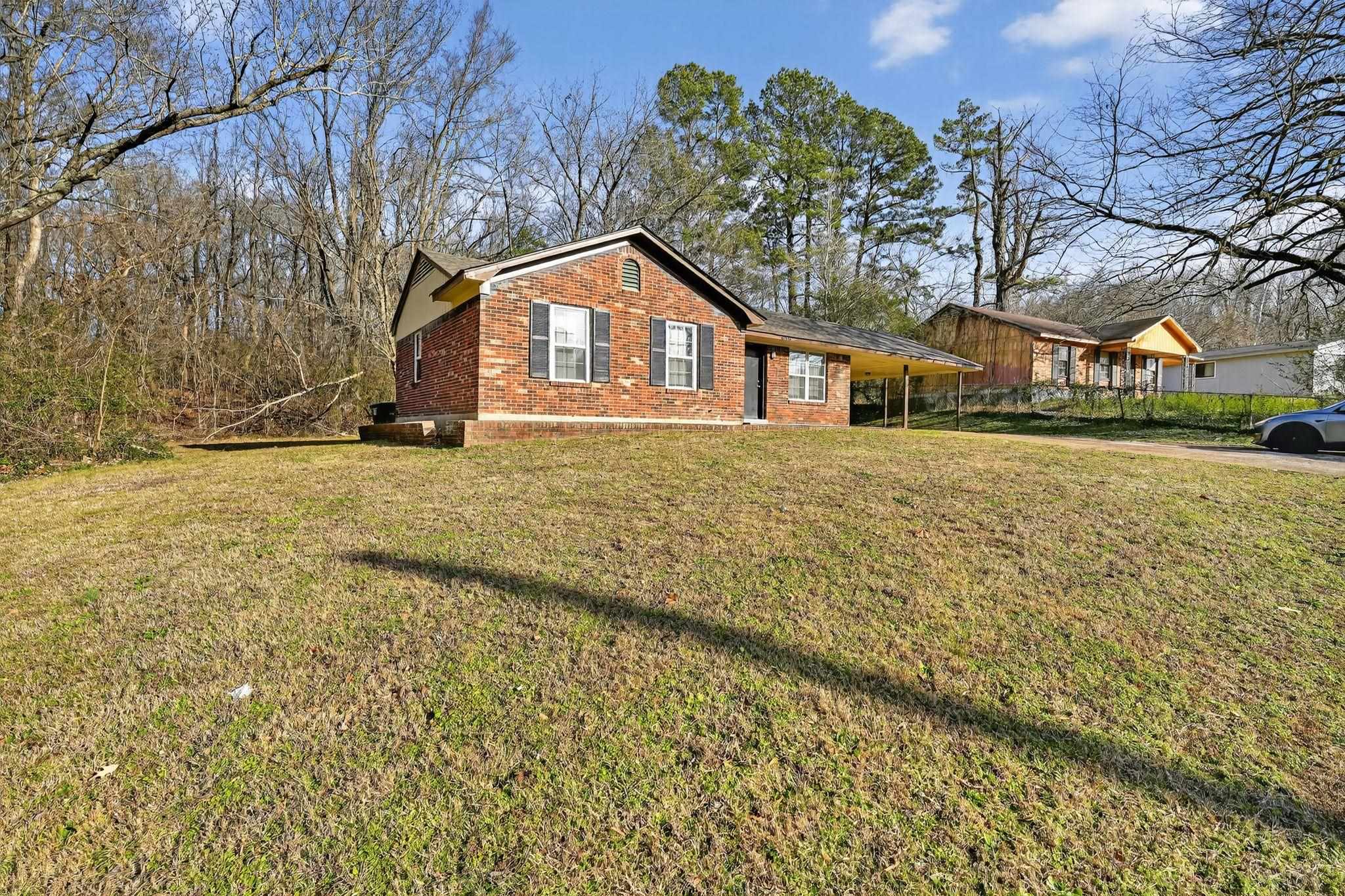 4306 University Street Memphis, TN 38127 - Photo 2 of 26 Single story home with a front yard, brick siding, and an attached carport