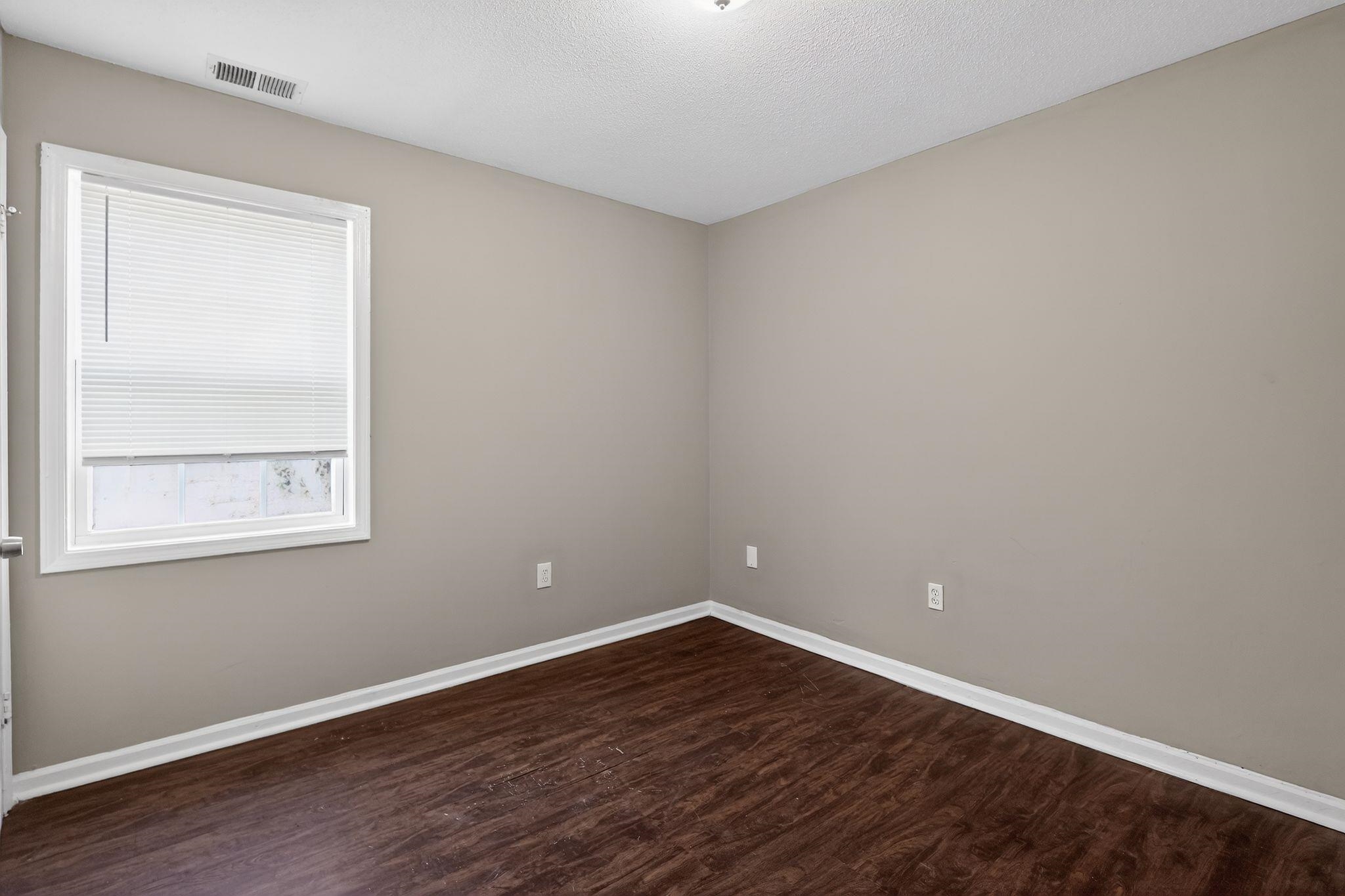 4306 University Street Memphis, TN 38127 - Photo 9 of 26 Empty room with dark wood-style floors and a textured ceiling