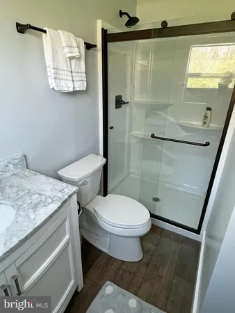 a bathroom with a granite countertop sink toilet and shower