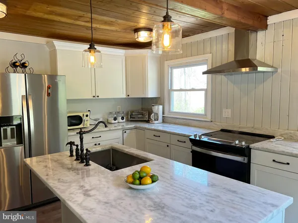 a kitchen with a sink a counter top space appliances and cabinets