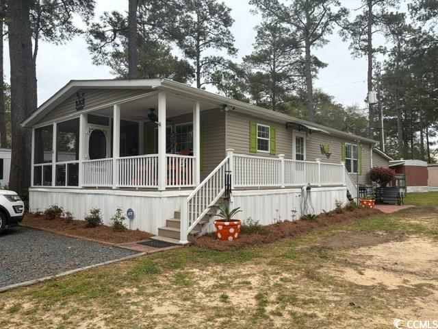 Manufactured / mobile home featuring covered porch and a front lawn