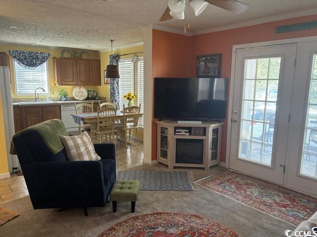 449 East Bank Dr Garden Murrells Inlet, SC 29576 - Photo 15 of 31 Living room featuring light tile patterned floors, a textured ceiling, a ceiling fan, and crown molding