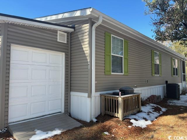 449 East Bank Dr Garden Murrells Inlet, SC 29576 - Photo 5 of 31 View of side of property with an attached garage and central AC unit