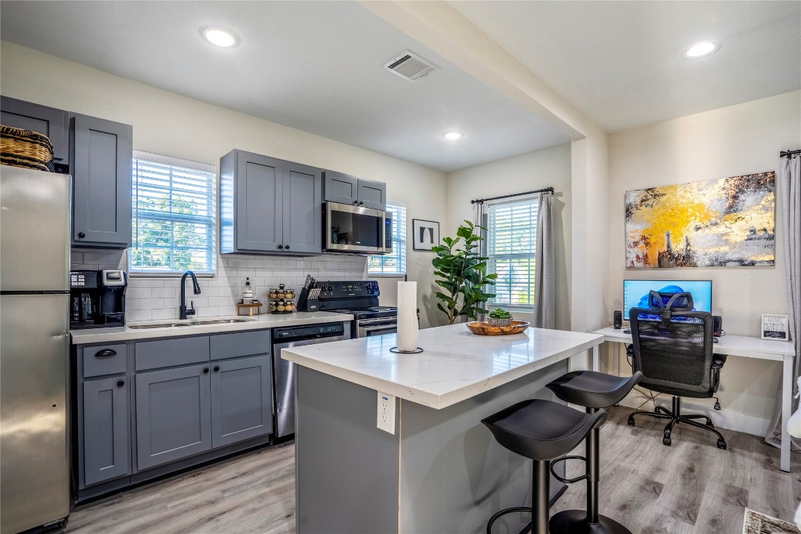 5 Estelle Street, Unit 1 Houston, TX 77003 - Photo 27 of 33 a kitchen with a stove a sink a microwave a dining table and chairs