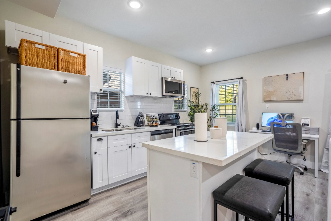 5 Estelle Street, Unit 1 Houston, TX 77003 - Photo 7 of 33 a kitchen with a refrigerator a stove a microwave a dining table and chairs