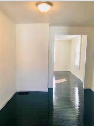 a view of an empty room and wooden floor