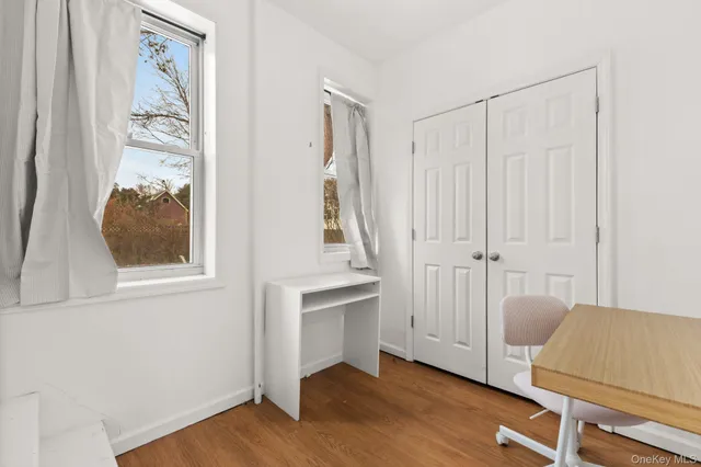an entryway with wooden floor and cabinet