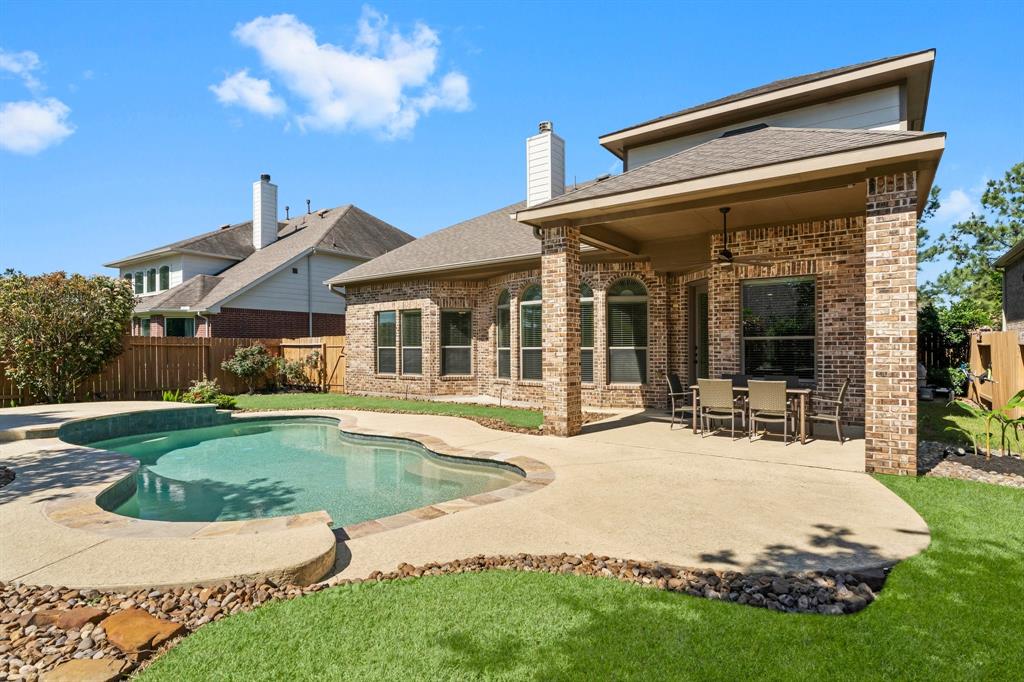 a swimming pool with patio outdoor seating and yard in the back