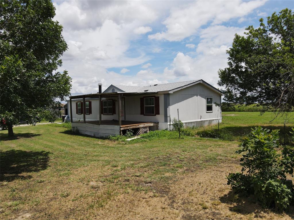 15962 Fritcher Road Pilot Point, TX 76258 - Photo 17 of 24 Rear view of property featuring a yard