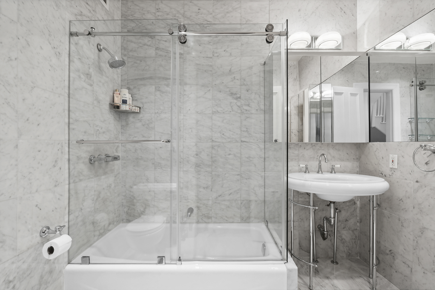 152 East 63rd Street, Unit 2 Manhattan, NY 10065 - Photo 16 of 23 a bathroom with a shower a mirror and a sink
