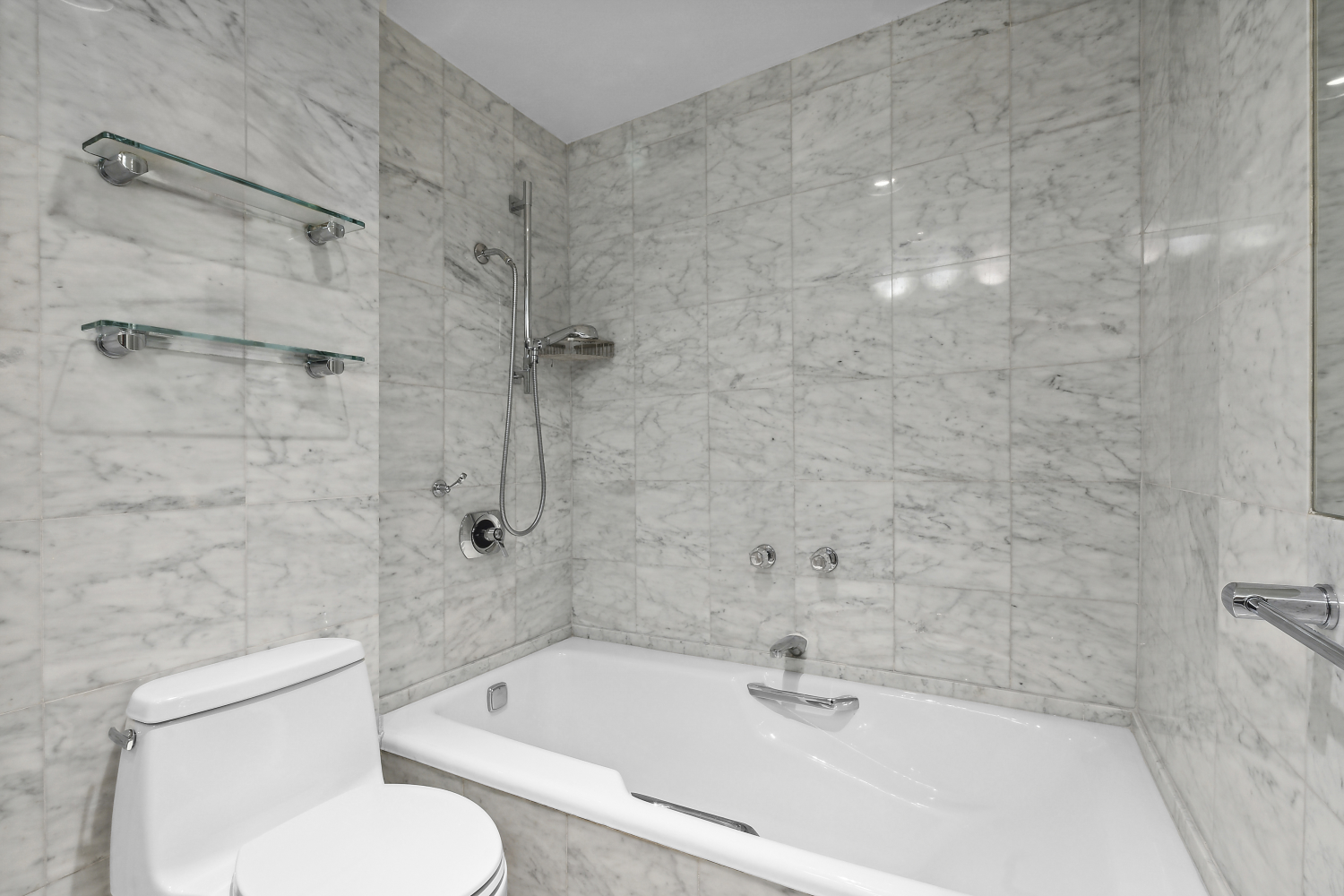 152 East 63rd Street, Unit 2 Manhattan, NY 10065 - Photo 19 of 23 a bathroom with a bathtub shower sink mirror and toilet